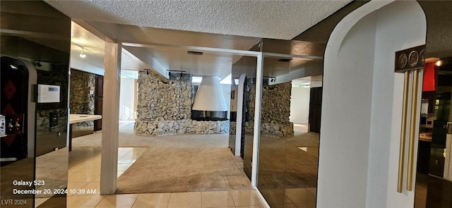 hall featuring tile patterned flooring and a textured ceiling