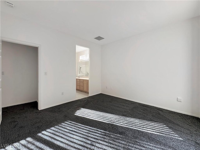 unfurnished bedroom with light colored carpet and ensuite bath