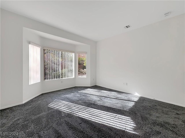 empty room with dark colored carpet