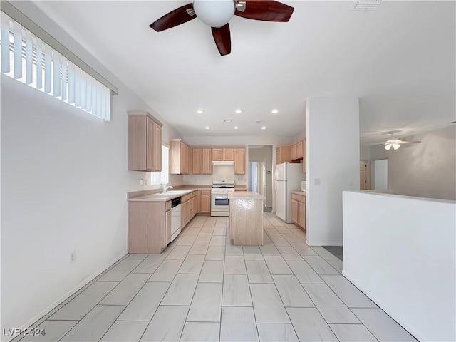 kitchen featuring light brown cabinetry, white appliances, ceiling fan, sink, and a kitchen island