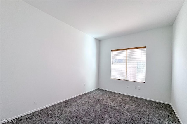 unfurnished room featuring dark colored carpet