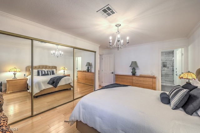 bedroom with hardwood / wood-style floors, crown molding, a closet, and a notable chandelier