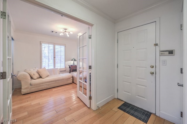 foyer entrance with light hardwood / wood-style floors and ornamental molding