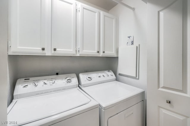 laundry area with washer and clothes dryer and cabinets