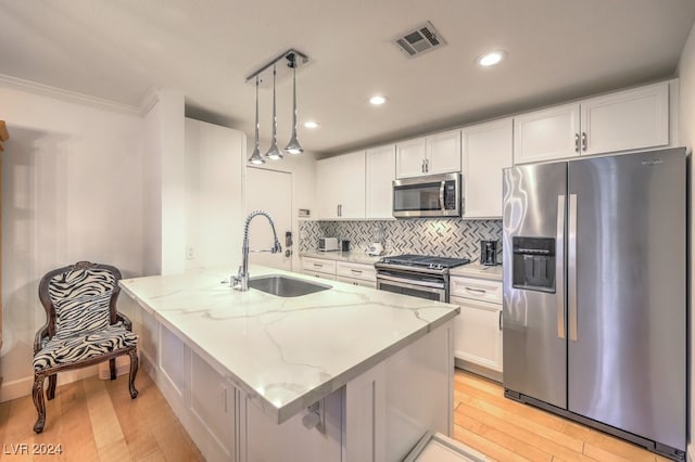 kitchen with appliances with stainless steel finishes, light hardwood / wood-style flooring, white cabinetry, and sink