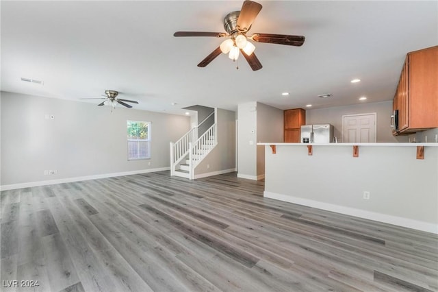 unfurnished living room with ceiling fan and light wood-type flooring