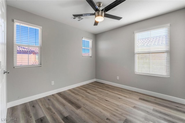 empty room with ceiling fan and light hardwood / wood-style flooring