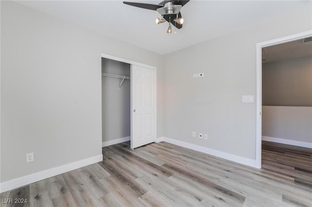 unfurnished bedroom featuring ceiling fan, a closet, and light wood-type flooring