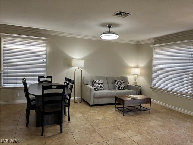 tiled dining area featuring crown molding