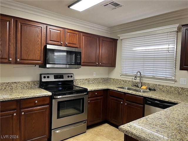 kitchen with crown molding, sink, light stone countertops, light tile patterned floors, and appliances with stainless steel finishes