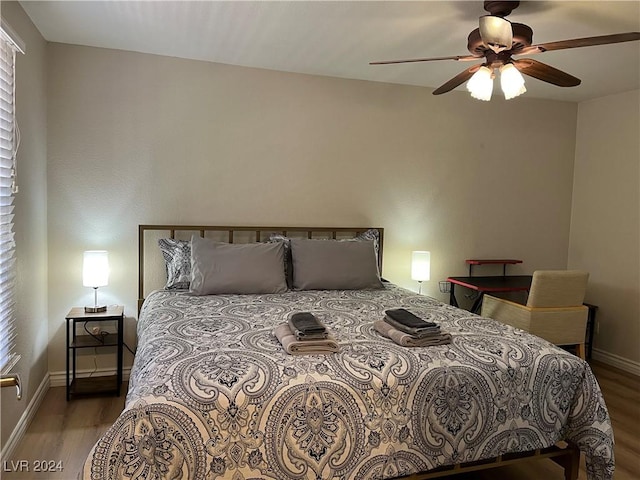 bedroom featuring multiple windows, hardwood / wood-style flooring, and ceiling fan