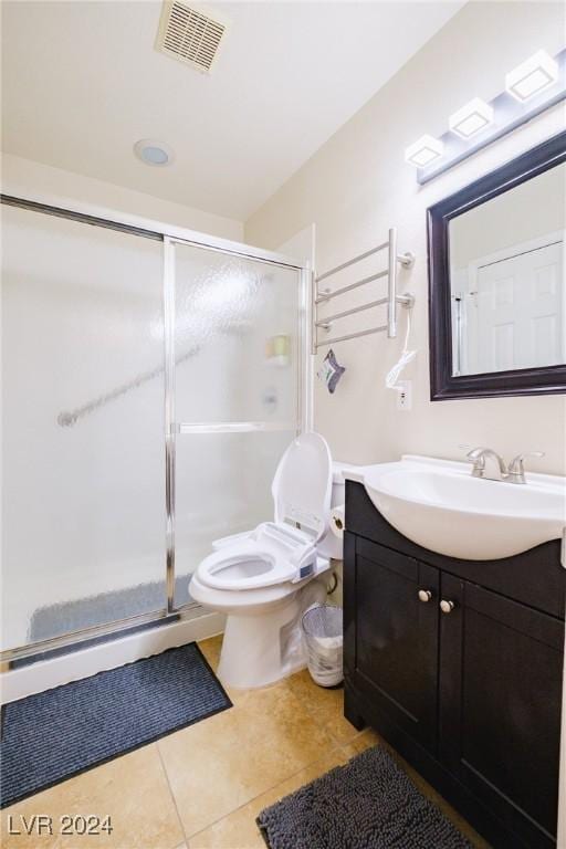 bathroom featuring tile patterned flooring, vanity, toilet, and walk in shower