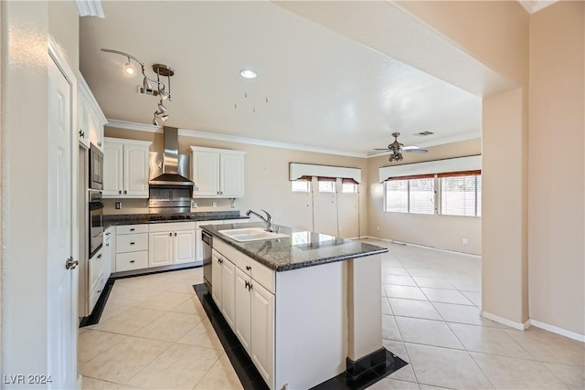 kitchen featuring white cabinetry, sink, wall chimney range hood, and appliances with stainless steel finishes