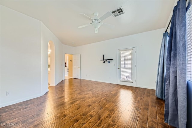 empty room with ceiling fan and dark wood-type flooring