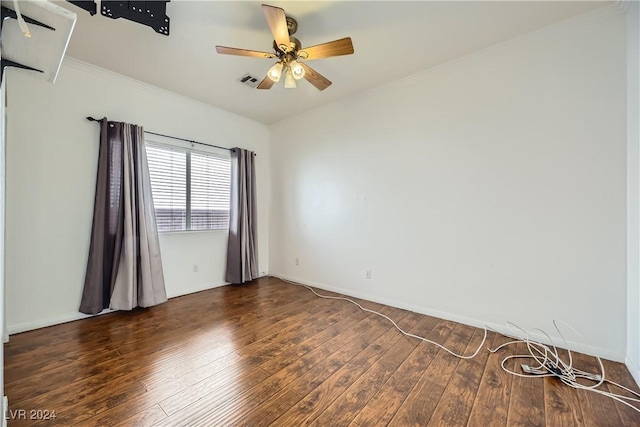 spare room featuring ceiling fan, ornamental molding, and dark wood-type flooring