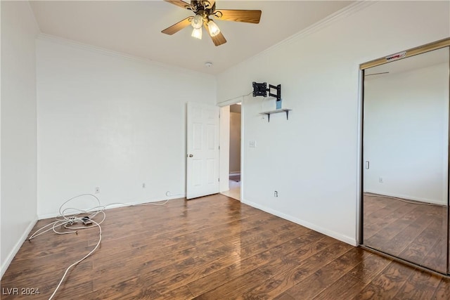 unfurnished bedroom with a closet, ceiling fan, dark hardwood / wood-style flooring, and crown molding