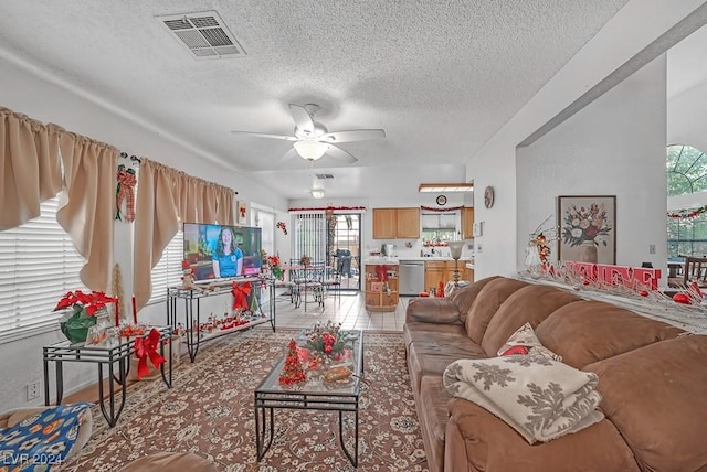 tiled living room featuring ceiling fan and a textured ceiling