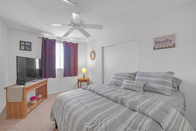 carpeted bedroom featuring a textured ceiling, a closet, and ceiling fan