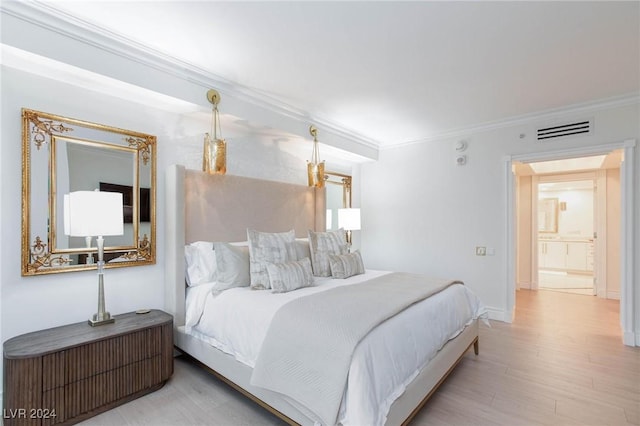 bedroom featuring ornamental molding and light hardwood / wood-style flooring