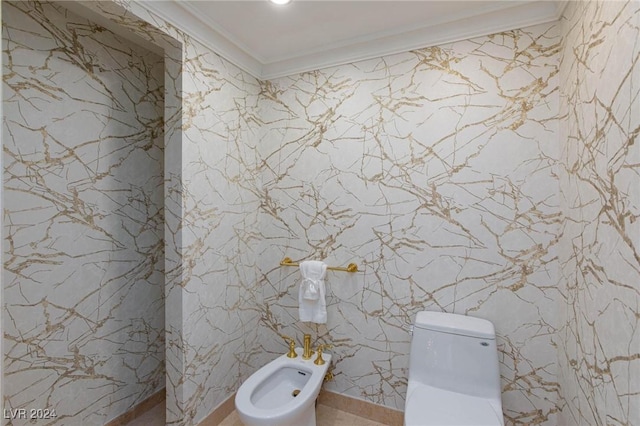 bathroom featuring toilet, crown molding, and a bidet