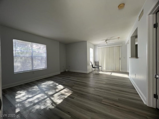 unfurnished living room with ceiling fan and dark wood-type flooring