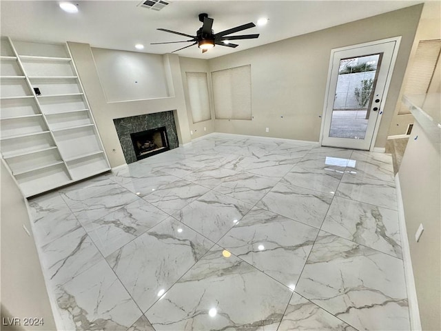 unfurnished living room featuring a fireplace and ceiling fan