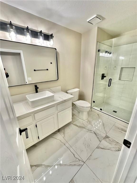 bathroom with toilet, vanity, a textured ceiling, and walk in shower