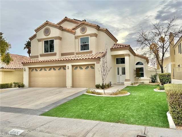 mediterranean / spanish home with a garage and a front lawn