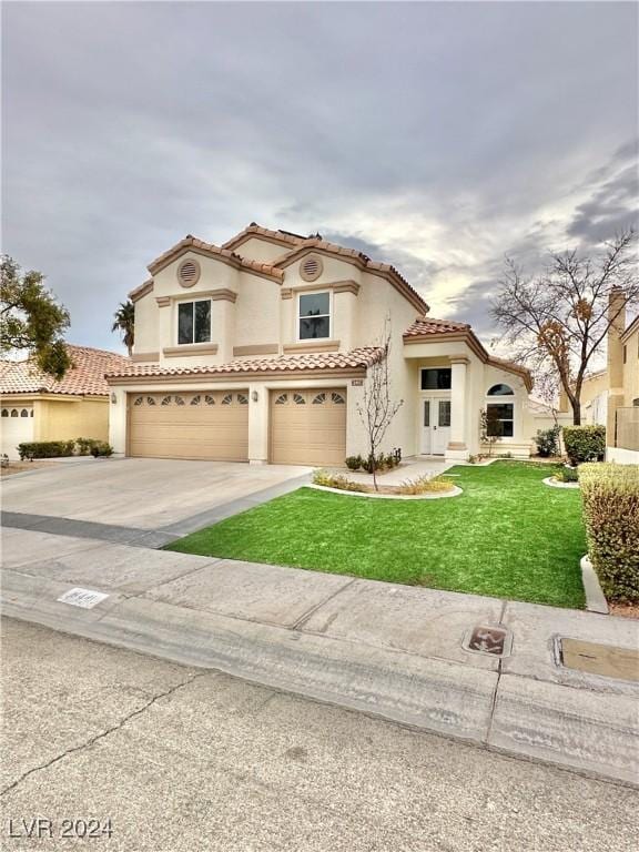 mediterranean / spanish house with a front yard and a garage