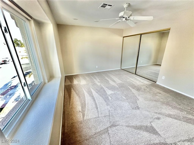 unfurnished bedroom featuring access to exterior, carpet floors, a closet, and ceiling fan