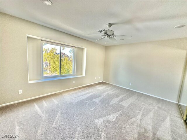 empty room featuring carpet flooring and ceiling fan