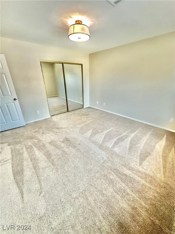 unfurnished bedroom featuring carpet floors and a closet