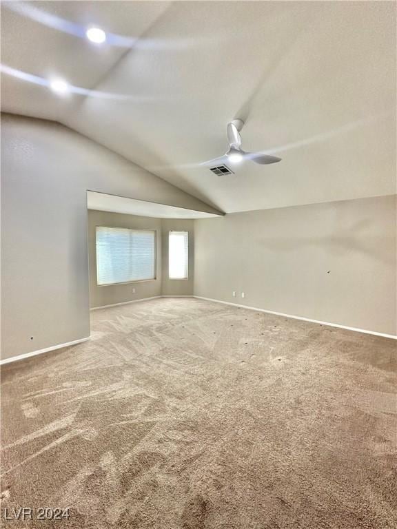 carpeted empty room with vaulted ceiling and ceiling fan