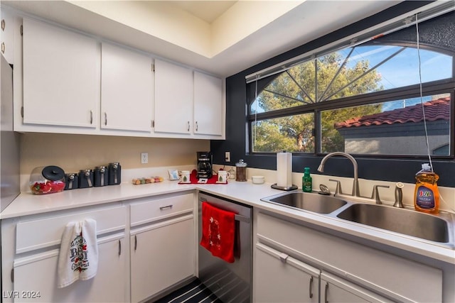 kitchen featuring dishwasher, white cabinetry, and sink