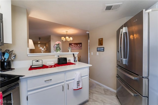 kitchen with white cabinets, decorative light fixtures, stainless steel fridge, a notable chandelier, and kitchen peninsula