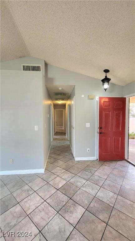 entryway featuring lofted ceiling and a textured ceiling