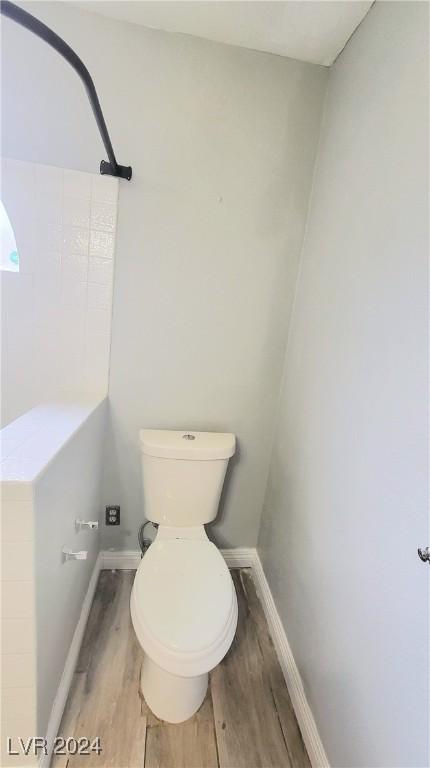 bathroom with wood-type flooring and toilet