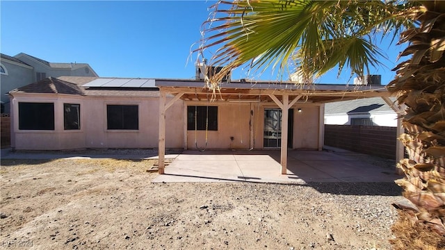 rear view of house featuring a patio area and solar panels