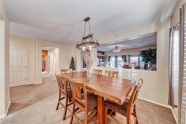 dining room with light carpet and ceiling fan