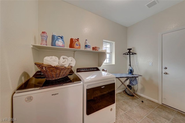 washroom featuring washing machine and dryer and light tile patterned floors