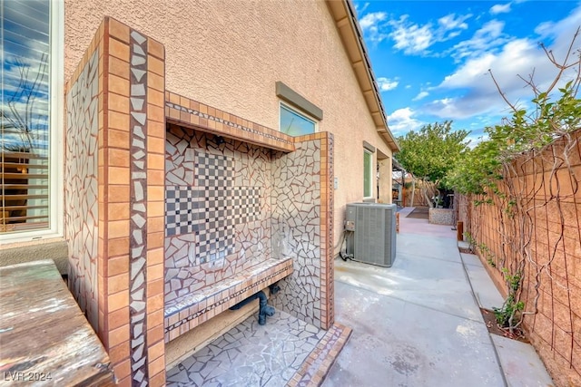 view of side of home with a patio area and central AC