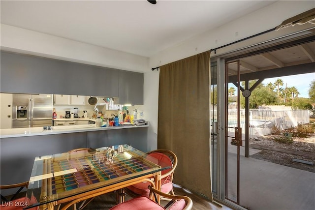 kitchen with kitchen peninsula, stainless steel fridge with ice dispenser, and hardwood / wood-style flooring