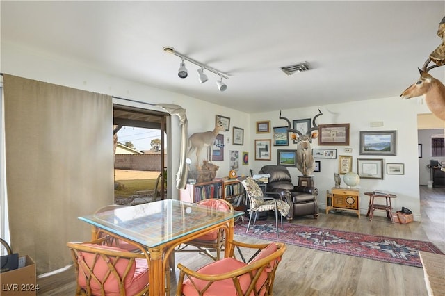 dining room with hardwood / wood-style floors and track lighting