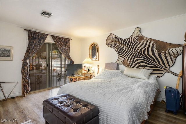 bedroom featuring access to exterior and dark hardwood / wood-style flooring