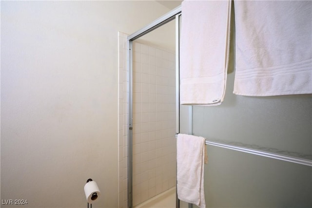 bathroom featuring a shower with shower door