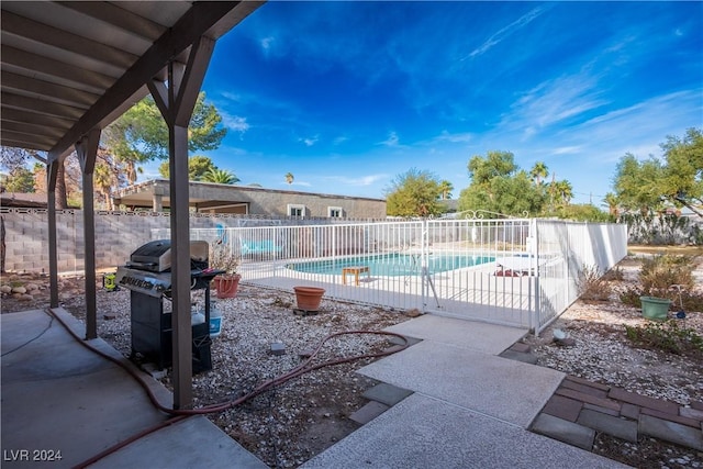 view of swimming pool featuring a grill and a patio