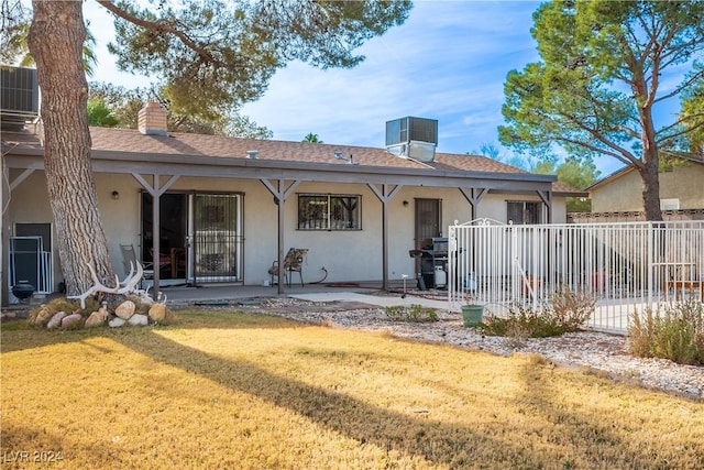 back of house featuring a lawn, a patio area, and cooling unit