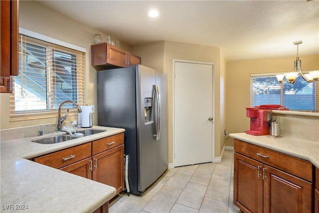 kitchen featuring sink, an inviting chandelier, stainless steel fridge with ice dispenser, hanging light fixtures, and light tile patterned floors