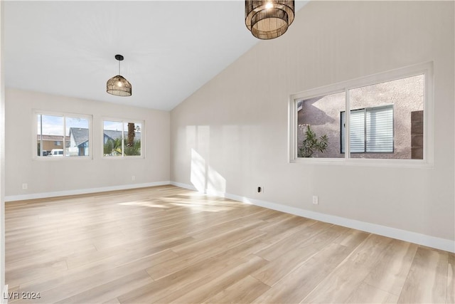 spare room featuring light wood-type flooring and high vaulted ceiling