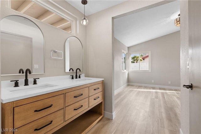 bathroom with wood-type flooring, vanity, and lofted ceiling